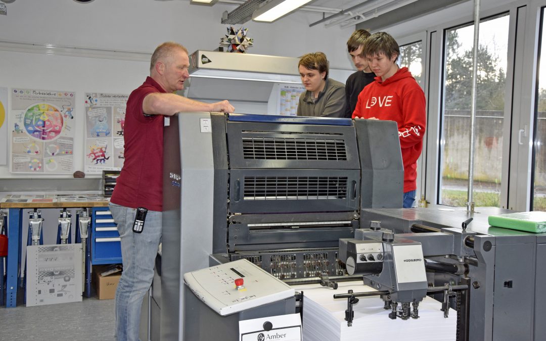 Auszubildende und Ausbilder vor der neuen Druckmaschine in der BvB
